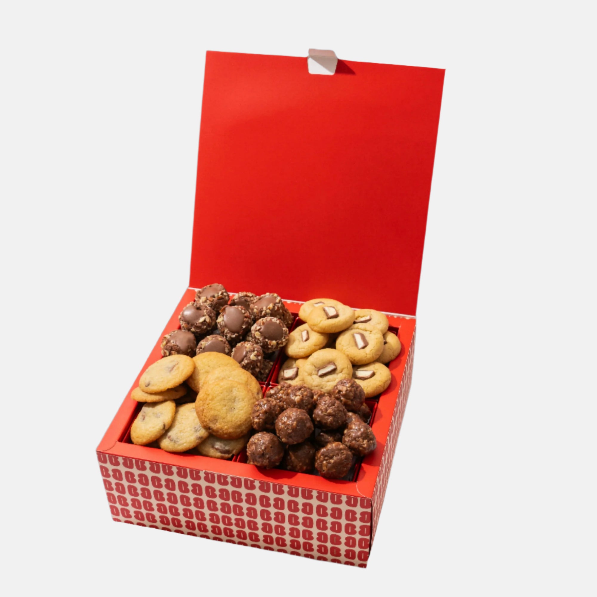 Open red gift box filled with assorted cookies on a white background